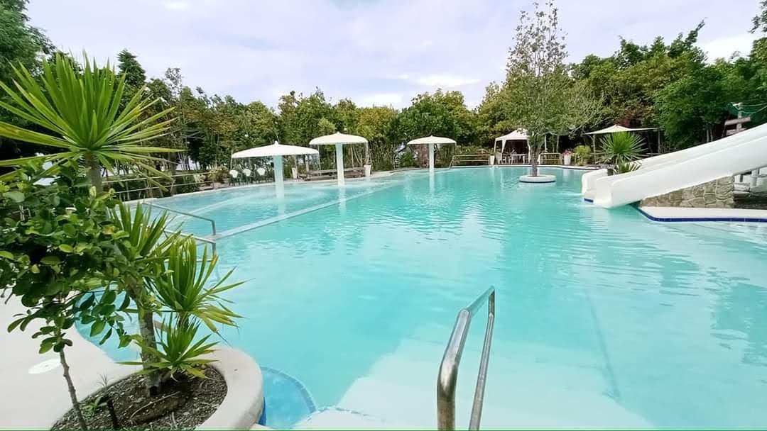 Pool area with slide and umbrellas